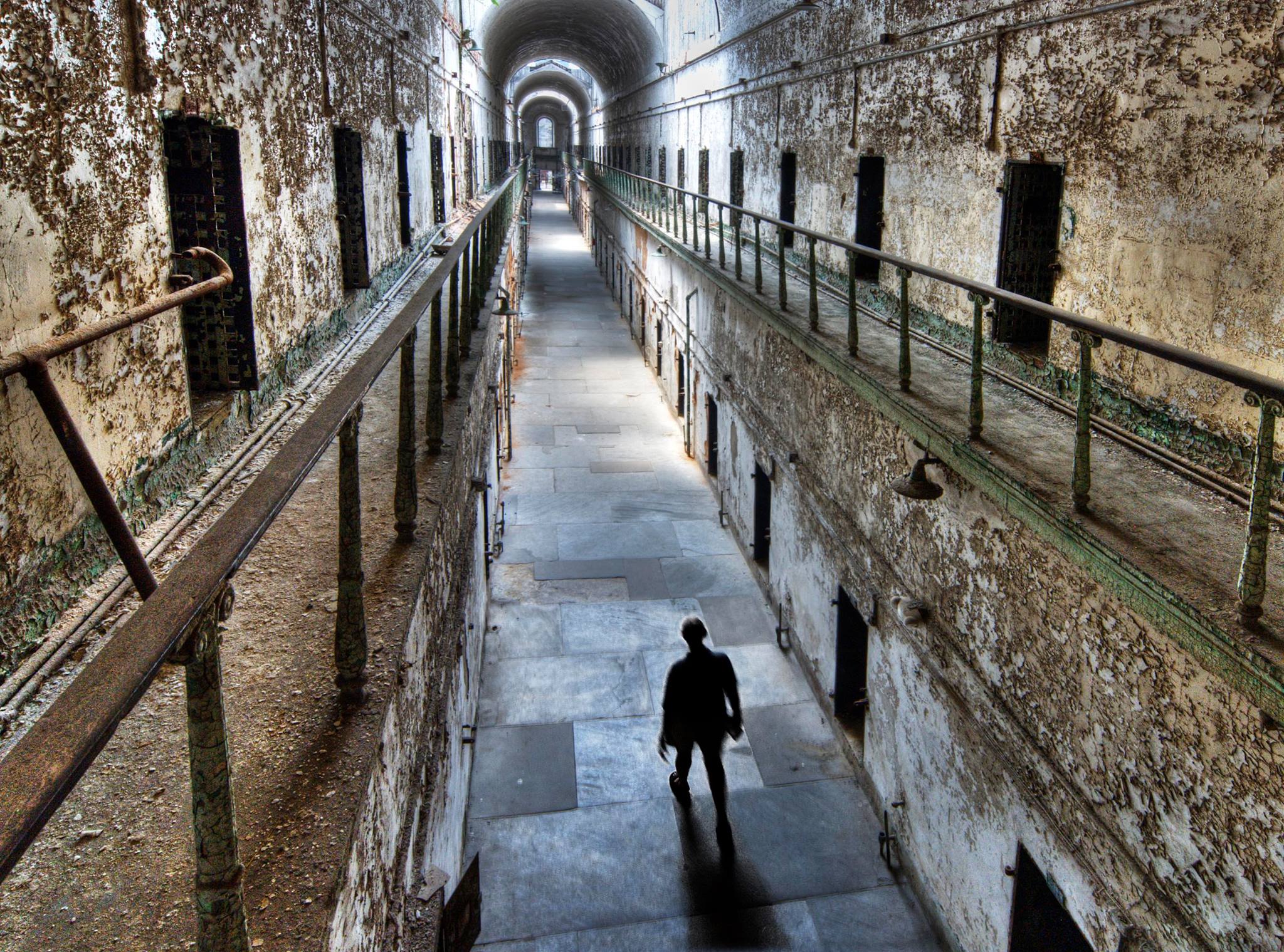 Person walking down a long eerie jail hallway