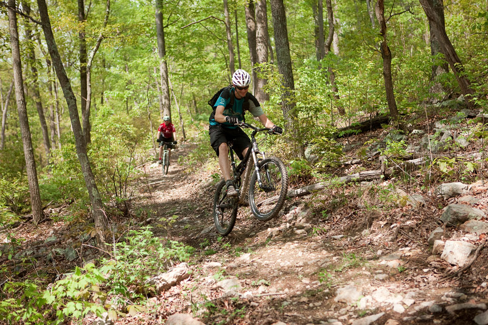 two mountain bikers biking mountain trails