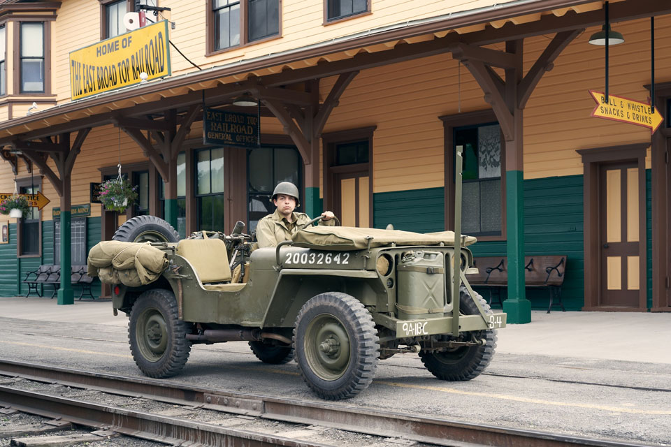 a solider sitting in a jeep at Train station