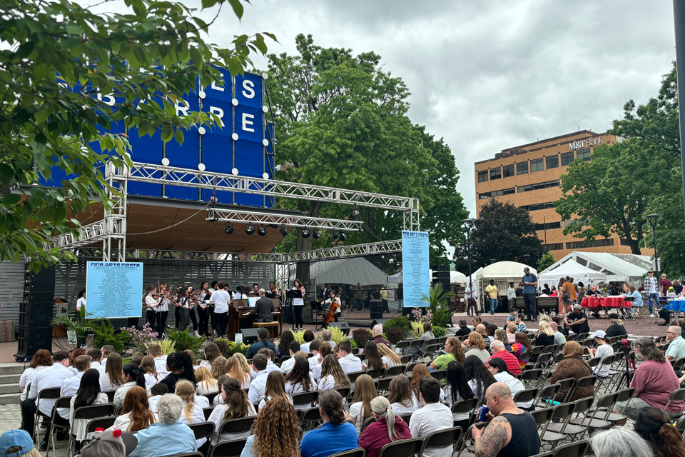 Symphony performance on the stage with audience sitting in chairs in front