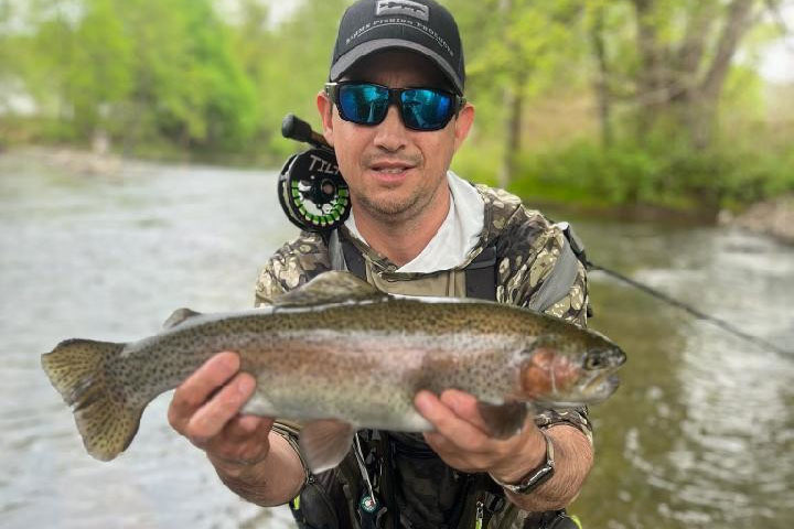 A person holding a wild caught Trout in Hand