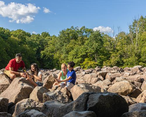A family sitting on rocks at Ringing rocks park